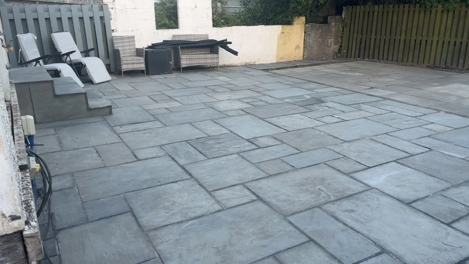Indian sandstone patio with garden loungers in Kilwinning.