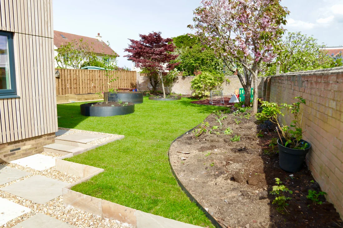 Garden landscaping with lawn and paved areas.