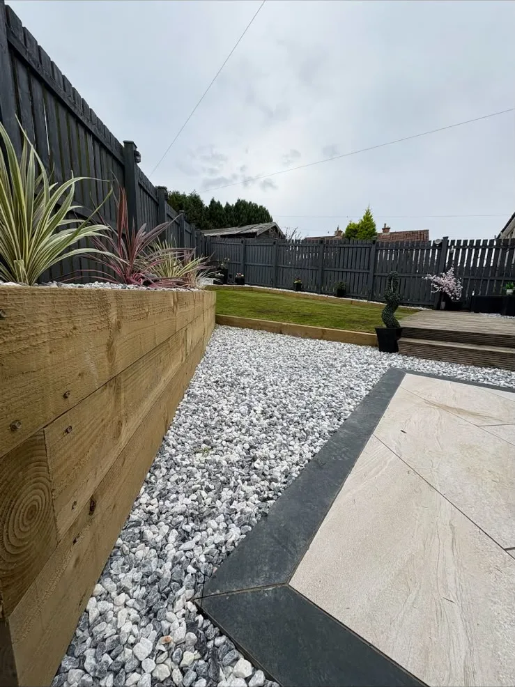 Sleeper flower bed running beside porcelain tiles and chips, Ayr.