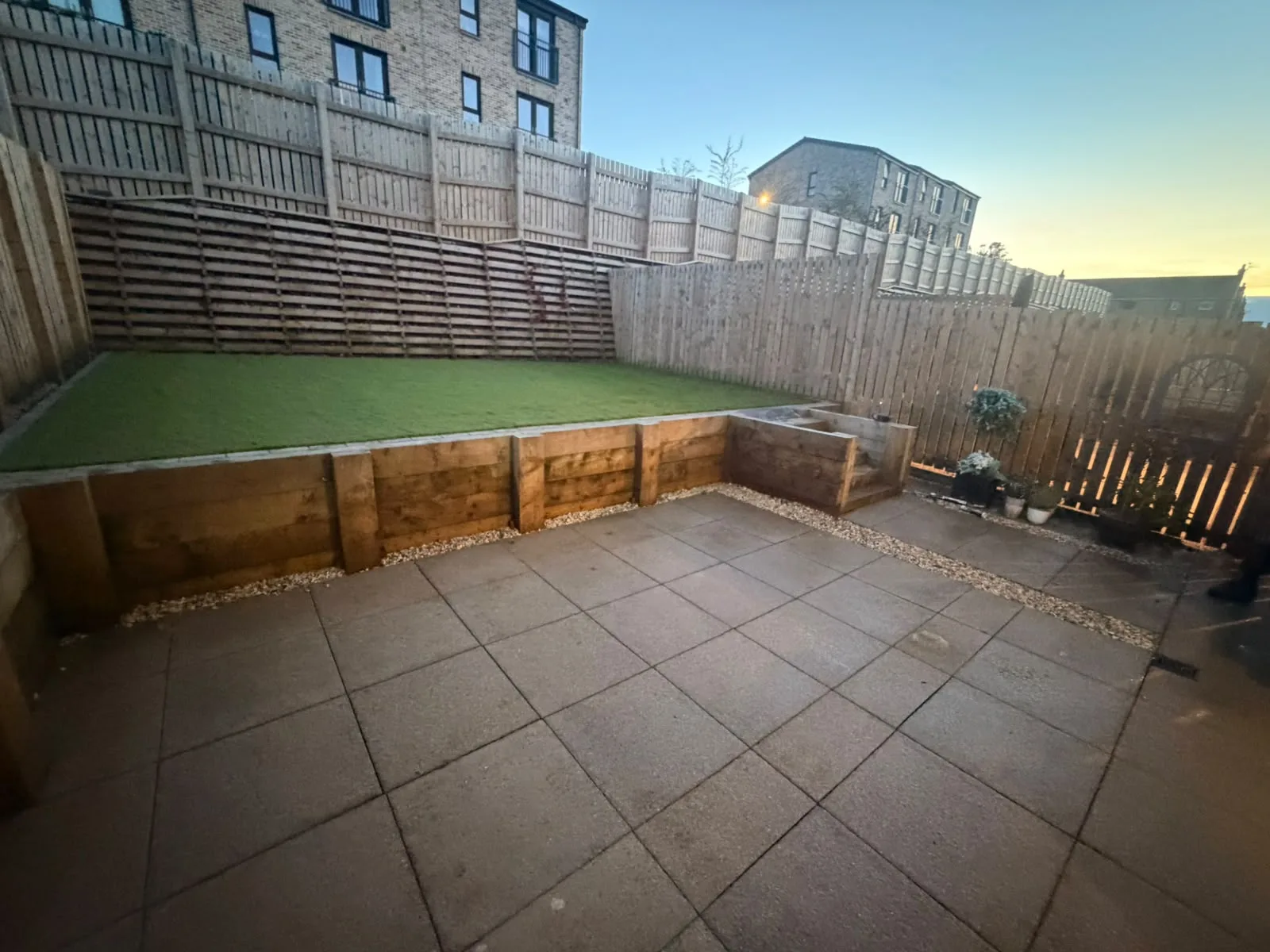 Sleeper steps beside a sleeper retaining wall above a slabbed patio.