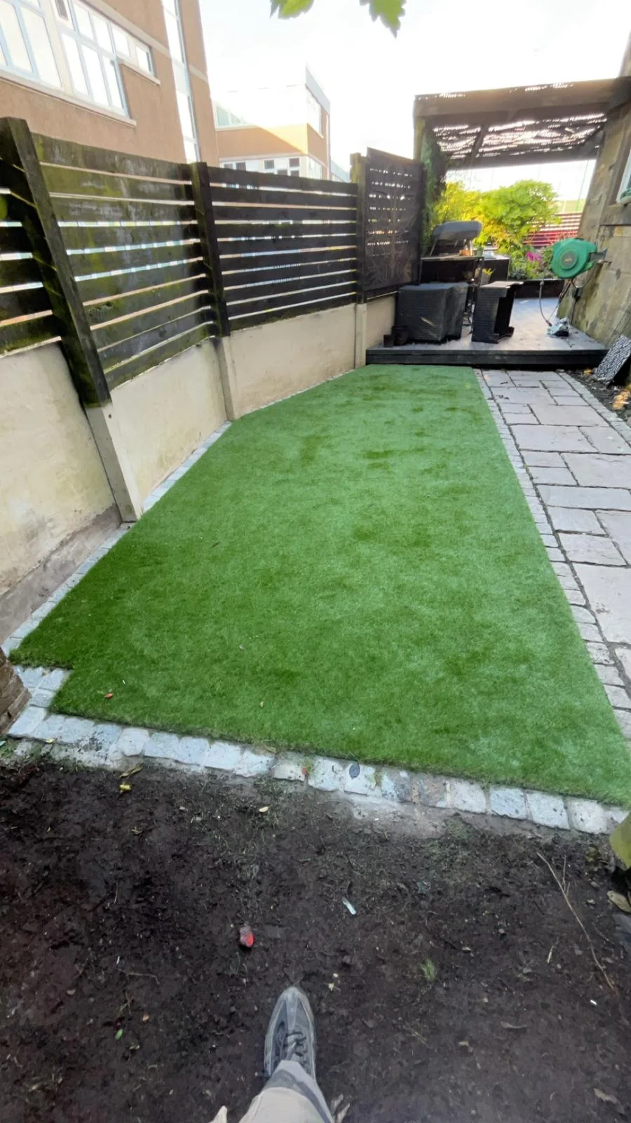 Artificial grass lawn running towards a decked seating area in Kilwinning.