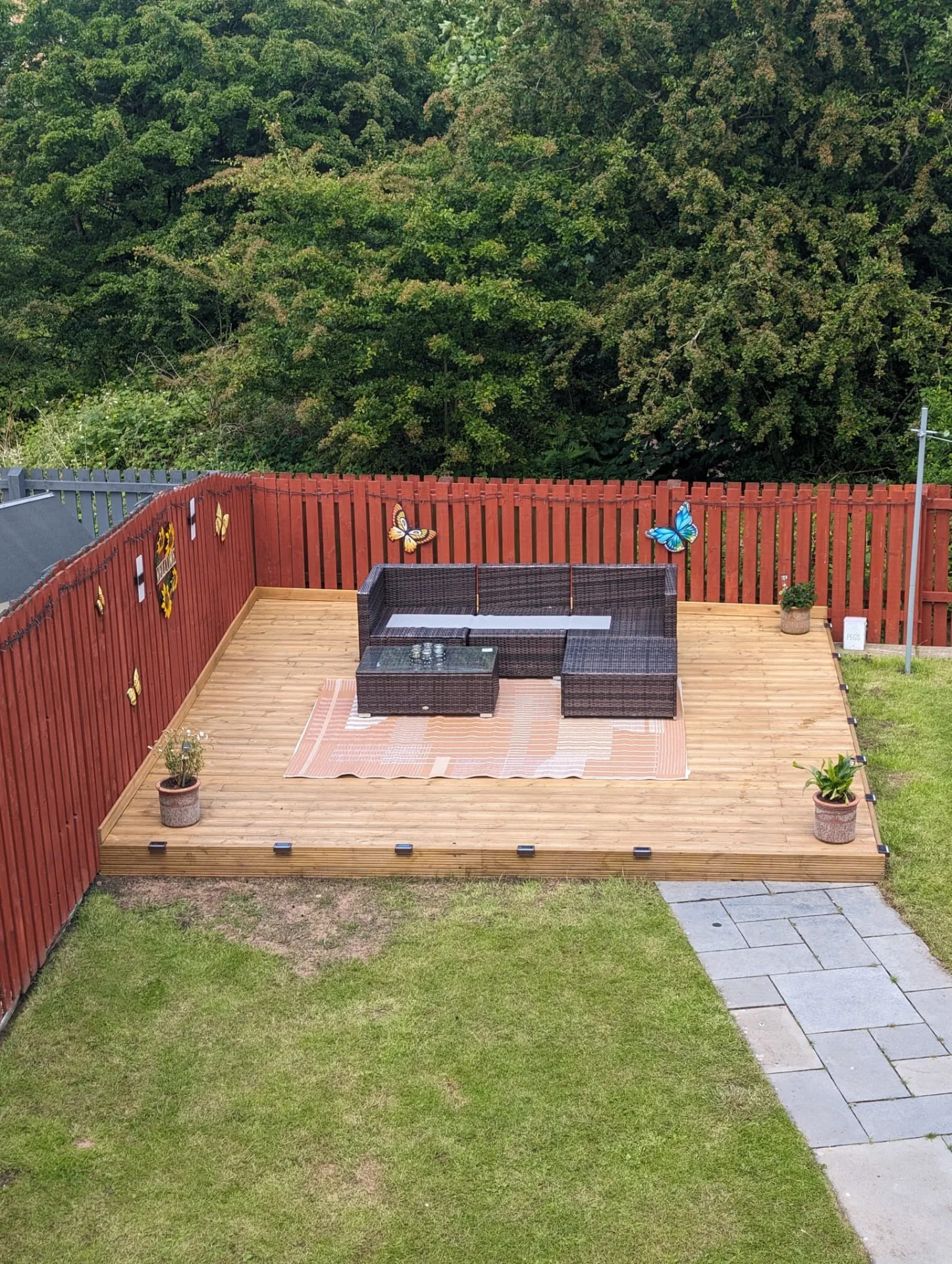 Raised timber deck with seating area and slab path.