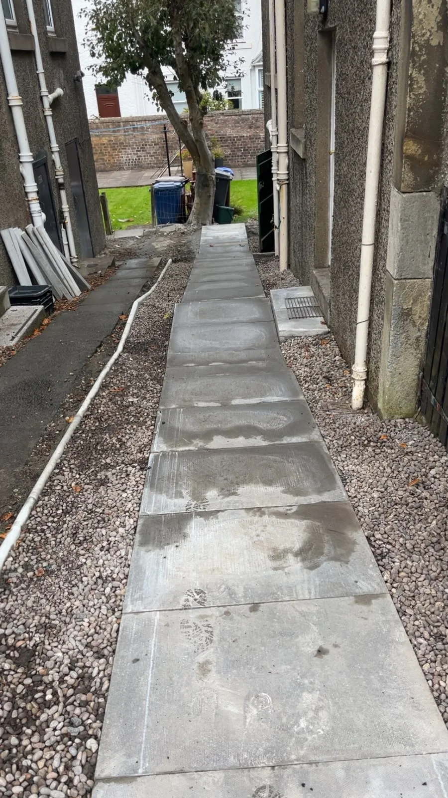 Slab side-return pathway with chip borders in Greenock.