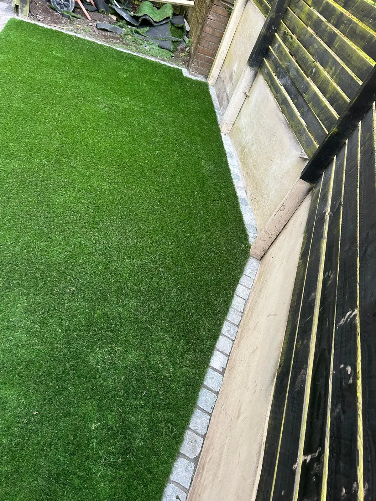 Close-up of artificial grass edged with stone setts in Kilwinning.